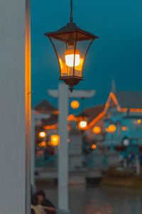Illuminated street light against sky at dusk