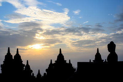 Low angle view of silhouette temple against cloudy sky