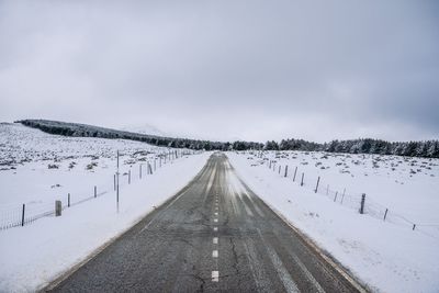 Snow covered road against sky