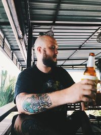 Young man drinking beer in glass