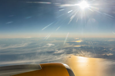 Airplane wing over sea against sky