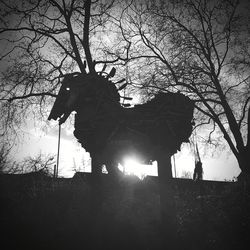Low angle view of silhouette bare tree on field against sky