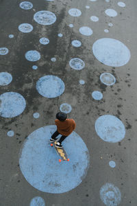High angle view of man with skateboard on footpath