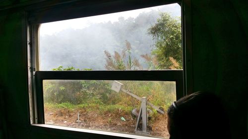 Man looking through window at home