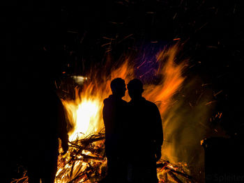 Silhouette of man with fire crackers at night