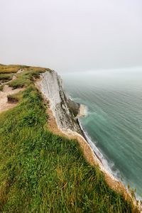 Scenic view of white cliffs of dover and sea against clear sky