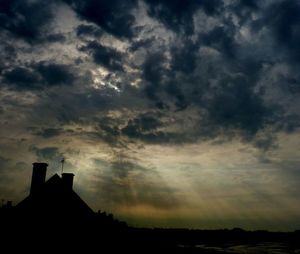 Silhouette of built structure against cloudy sky