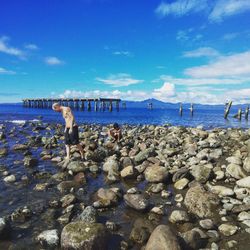 View of people on beach against blue sky