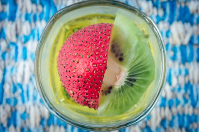 Directly above of kiwi and strawberry drink in glass on table