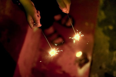 Low angle view of hand holding sparkler at night