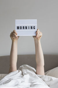 Low angle view of woman hand on bed at home