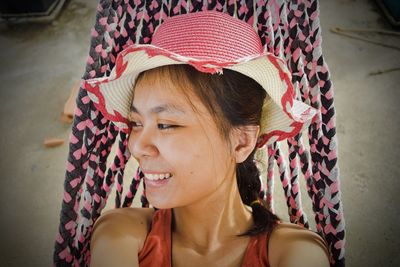 Woman wearing sun hat while relaxing on hammock