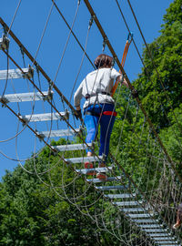 Rear view of woman walking on footbridge