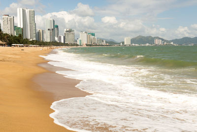 Scenic view of sea by buildings against sky