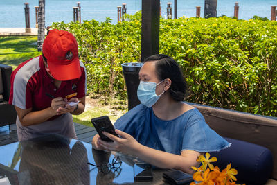 Friends holding mobile phone outdoors