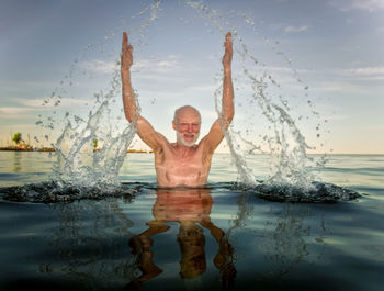 Portrait of smiling man in swimming pool against sky