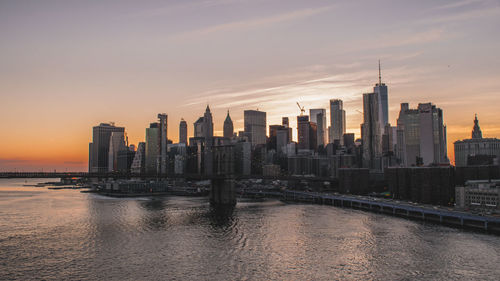 Modern buildings in city against sky during sunset