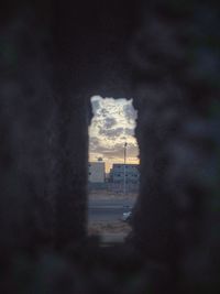 Buildings against sky seen through window