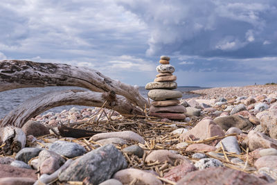 Stack of stones on rock against sky