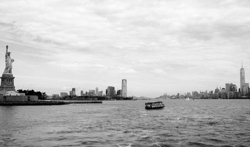 Boats in river with city in background