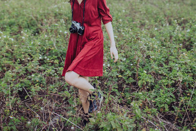 Low section of woman walking on field