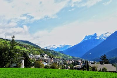 Houses by mountains against sky in town