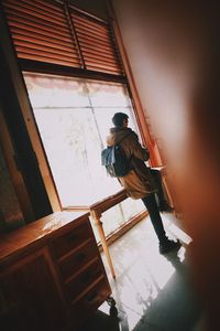 Low angle view of man standing in ladder