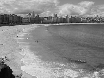 Scenic view of sea by buildings against sky