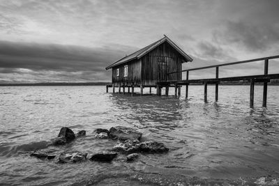 Pier over sea against cloudy sky