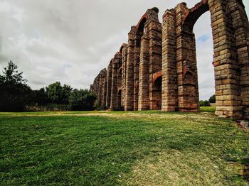 Old ruin building on field against cloudy sky