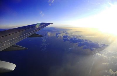 Cropped image of airplane flying over clouds