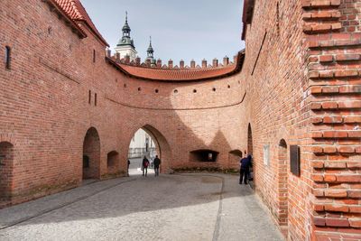 Man walking on cobblestone street in city