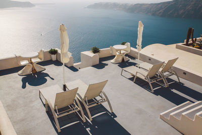 High angle view of white lounge chairs at tourist resort by sea