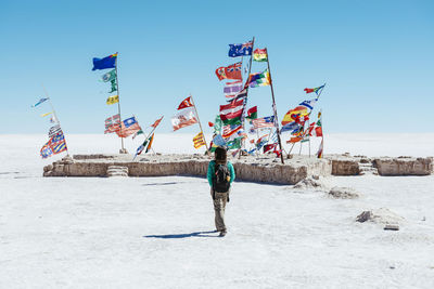 Rear view of man standing on land against sky