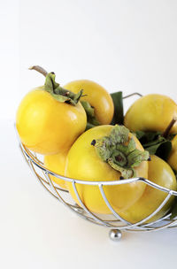 Close-up of fruits in bowl over white background