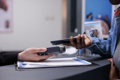 Midsection of man using mobile phone at table