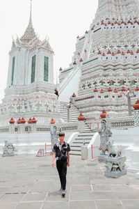 Full length of man standing outside temple against building