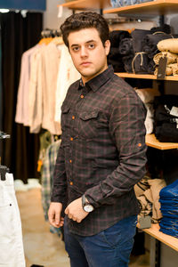 Portrait of young man standing in store
