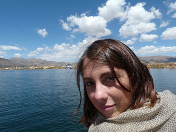 Portrait of smiling young woman against sea