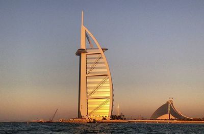 Boats in sea against clear sky