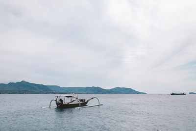 Fishing boat in sea against sky