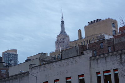 Low angle view of buildings against cloudy sky