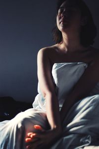 Close-up of young woman relaxing on bed at home