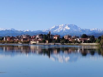 Scenic view of lake by buildings against sky