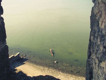 High angle view of man standing on rock by sea
