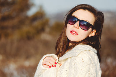 Portrait of woman wearing sunglasses standing outdoors