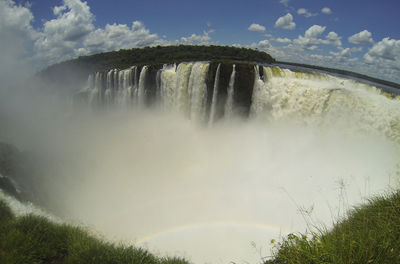 Scenic view of waterfall against sky