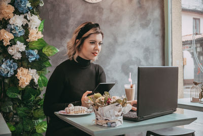 Young woman using smart phone on table