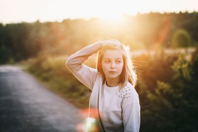 Woman with hand in hair on sunny day