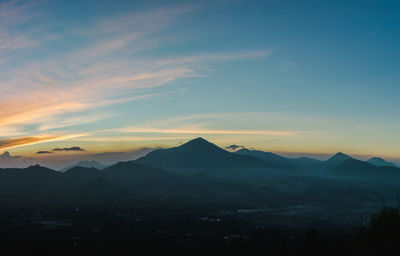 Scenic view of silhouette mountains against sky during sunset